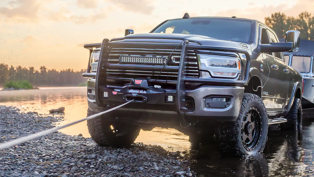 WARN ZEON XD 10-S 10,000 lb truck, Jeep, and SUV winch shown on an off-road vehicle near a river