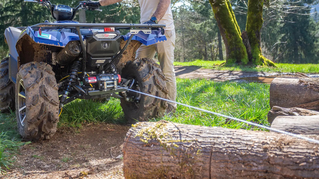 WARN R45 4,500 lb ATV/UTV winch shown near logs in an outdoor recovery scene