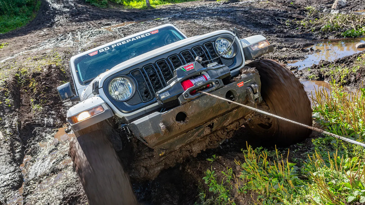 WARN ZEON XP 14-S 14,000 lb truck, Jeep, and SUV winch shown in muddy off-road terrain
