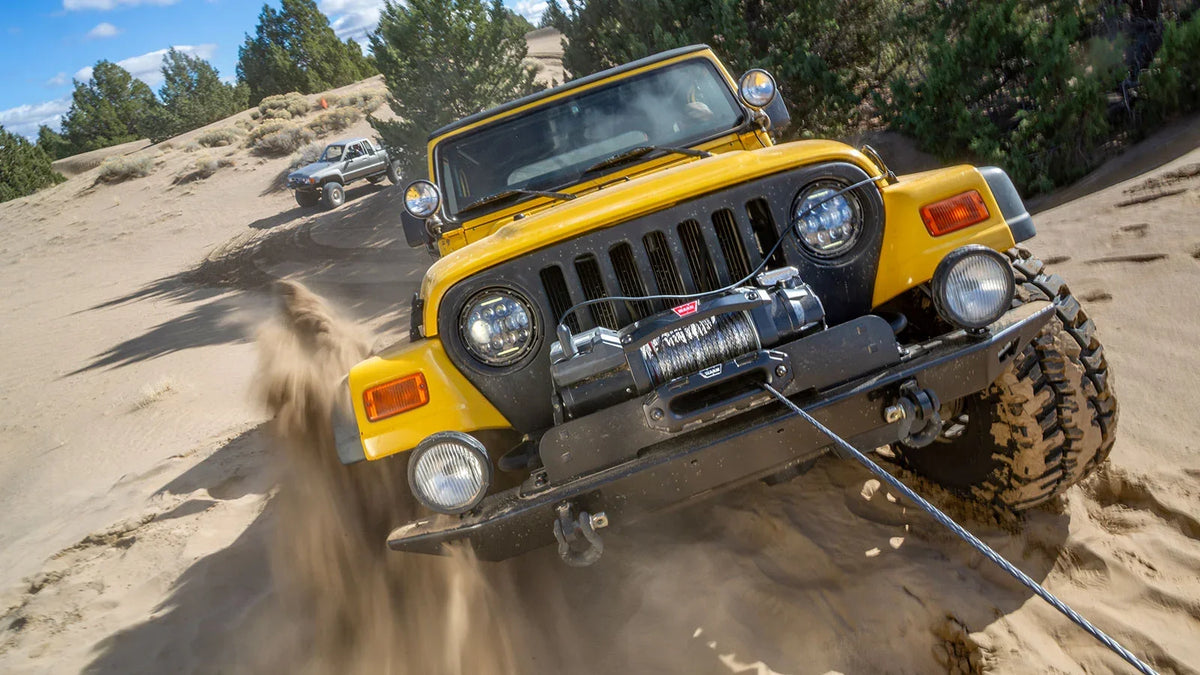 WARN ZEON XC 10-S 10,000 lb truck, Jeep, and SUV winch shown in sandy off-road terrain